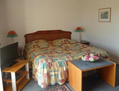 比伦德Havrevang的一间卧室配有一张床、一台电视和一张桌子