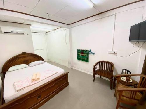 瓜拉丁加奴Nipah River View Bajet Hotel的一间卧室配有一张床、一台电视和一把椅子