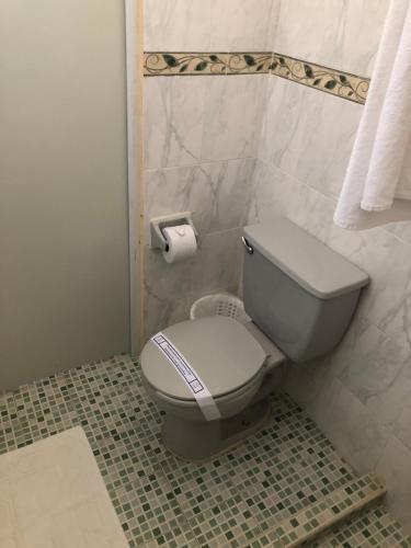 马德罗城行政套房酒店的浴室设有卫生间和一卷卫生纸