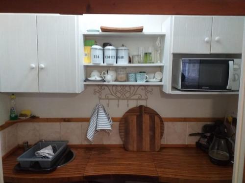 贝蒂湾索尔依松博拉公寓的厨房配有白色橱柜和微波炉