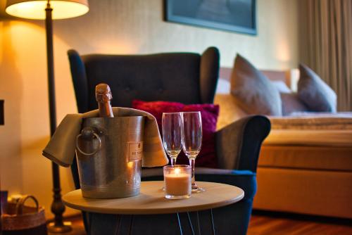 美因茨美因茨老城公寓酒店的一张桌子,上面有桶,眼镜和蜡烛