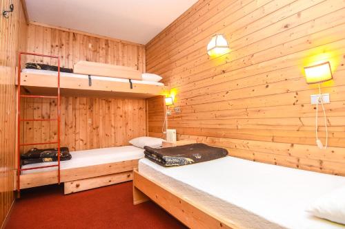 卡瓦莱塞Appartamenti Dolomiti con wellness的木墙内带两张双层床的客房