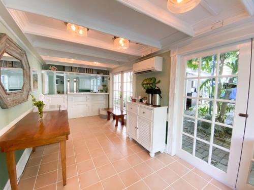 基韦斯特Authors Key West Guesthouse的一个带桌子和大窗户的大厨房