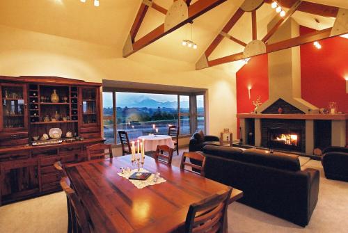 新普利茅斯Taranaki Country Lodge的客厅配有桌子和壁炉