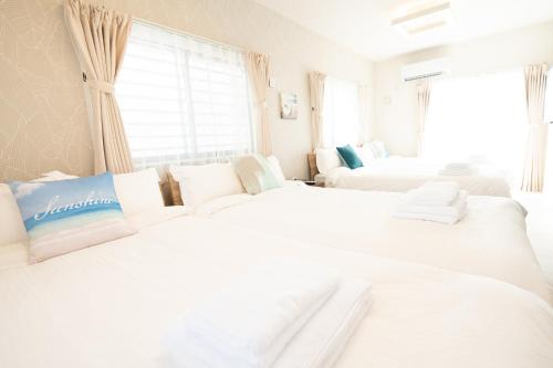 糸满ホテルトーマスみなみ的白色的客房配有两张床和一张沙发