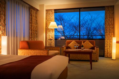 KasamaHotel Io Alpheratz的酒店客房带床、椅子和窗户