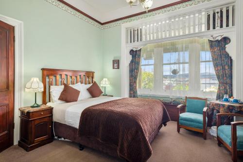 霍巴特Orana House的卧室配有床、椅子和窗户。