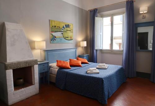 佛罗伦萨洛k安达德拉乐美酒店的一间卧室配有一张带橙色枕头的床和壁炉