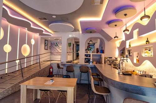 罗德镇N E P center Hotel Rodos的餐厅内的酒吧配有桌椅