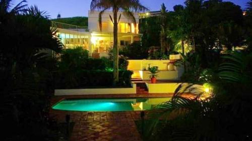 斯坦格Thoko-Zani Beach House的夜间在房子前面的游泳池