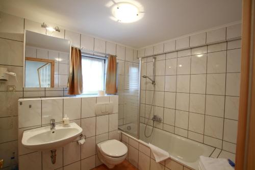 锡格马林根普非菲尔勒度假公寓式酒店的浴室配有盥洗盆、卫生间和浴缸。