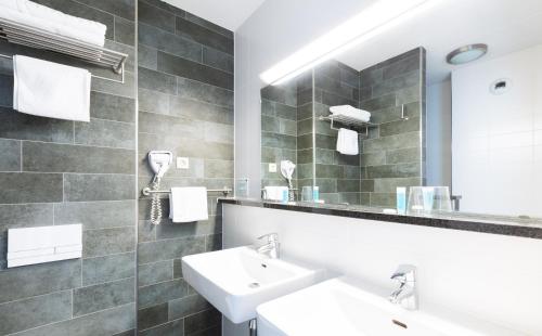 霍夫多普阿姆斯特丹机场堡垒酒店的浴室设有2个水槽和镜子