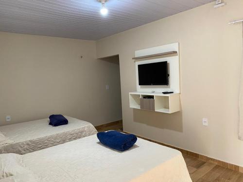 阿尔特杜尚Casa Ondas de Alter的客房设有两张床和一台墙上的电视。