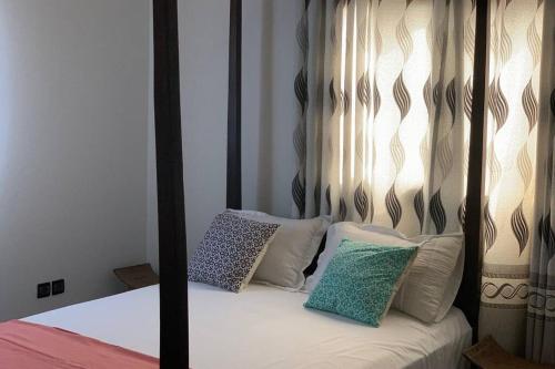 洛美Villa Luxury Baguida的一张带黑色和白色天蓬床及枕头的床