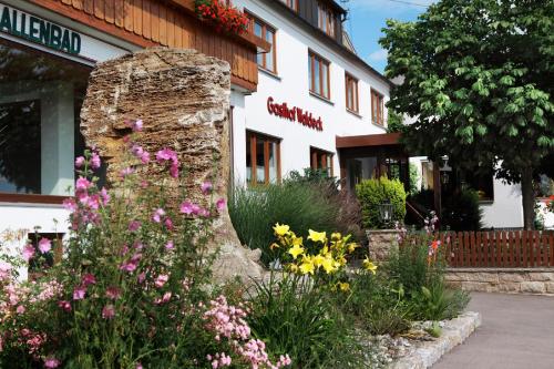 FremdingenLandhotel Waldeck - Ihr Urlaubshotel in der Natur的一座建筑前的鲜花花园