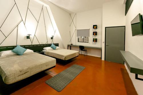 马那瓜D' LA TORRE HOTEL的一间卧室配有两张床、一张桌子和一面镜子