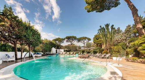 伊斯基亚Hermitage Resort & Thermal Spa的一个带椅子和树木的大型游泳池