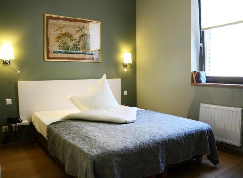 迪弗当日神父邸旅馆的一间卧室配有带白色枕头的床