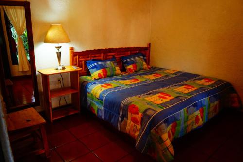 迪坡斯特兰霍斯佩达耶拉霍加旅馆的一间卧室配有一张带彩色毯子和台灯的床