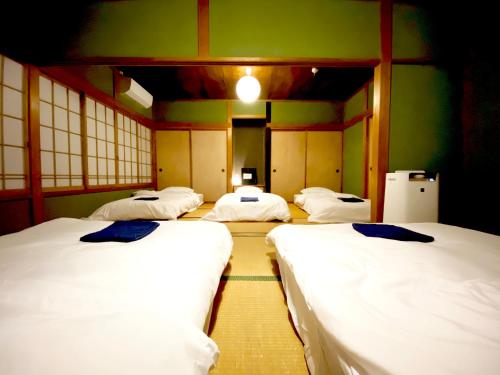 稻取湊庵錆御納戸-so-an sabionand-的绿色墙壁客房的四张床