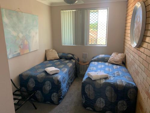 科夫斯港Beachlander Self-Contained Holiday Apartments的一间卧室设有两张床和窗户。