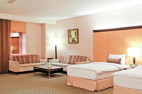 永康桂田酒店的酒店客房,设有两张床和一张沙发