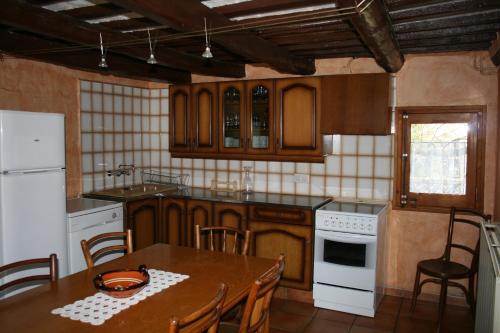 希罗内利亚卡尔西斯特勒度假屋的厨房配有桌子和白色冰箱。