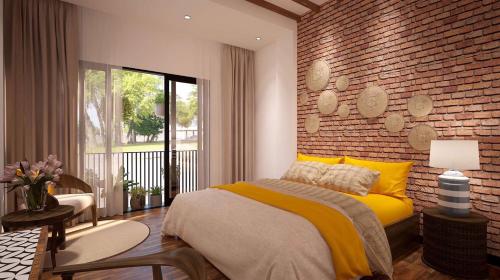 岘港Banana Flower Homestay的一间卧室设有黄色的床和砖墙