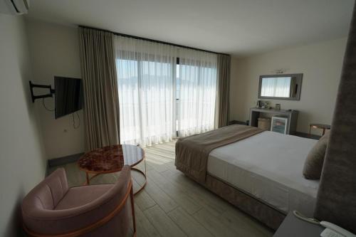 马尔马里斯尤努斯酒店的配有一张床和一把椅子的酒店客房
