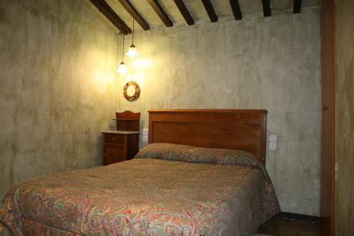 希罗内利亚卡尔西斯特勒度假屋的卧室配有一张床,墙上挂着一个钟