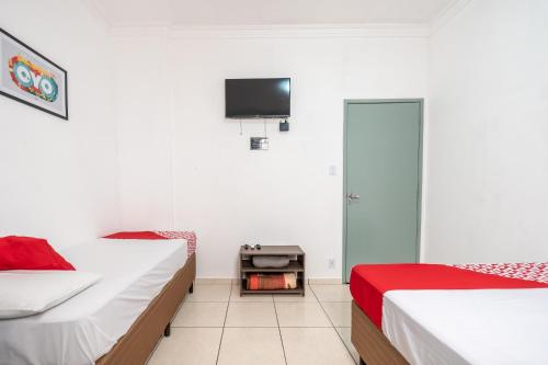 圣安德雷Hotel Florencio的一间卧室设有两张床,墙上配有电视。