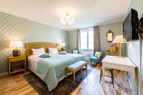 Krusenberg库瑞博歌酒店的一间卧室配有一张床、一张书桌和一台电视