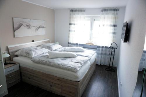 兰施泰因Ferienwohnung Persch的一间卧室配有一张带白色床单的床和一扇窗户。