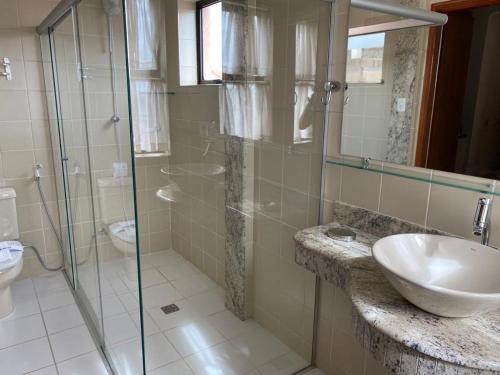阿尔费纳斯广场公寓酒店的一间带水槽和玻璃淋浴的浴室