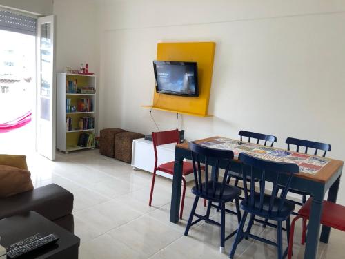 桑托斯Apto. frente ao mar no Gonzaga - melhor localização!的客厅配有桌椅和电视。