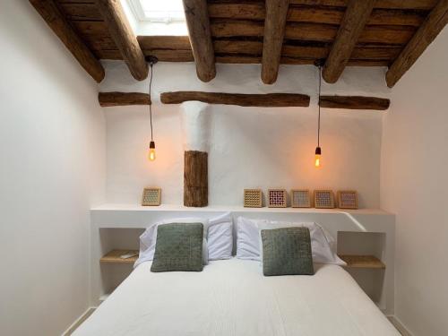 GaleraAstarte House 6 pax up的卧室配有白色床和2个绿色枕头