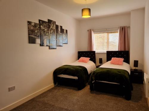 沃灵顿Stockton Heights, Warrington, Centrally Located Between Town Centre and Stockton Heath, High Speed Wifi, Cozy Stay的一间卧室配有两张带绿色和白色床单的床