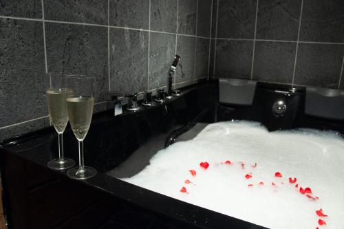 鲁卡Villa Rukapiste的浴缸内的2个香槟杯,有雪