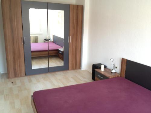 柏林"IDEAL" - für Zwei的一间卧室配有一张紫色的床和镜子