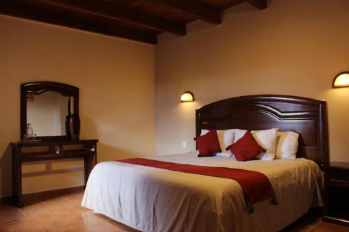 圣克里斯托瓦尔-德拉斯卡萨斯帕拉多玛格丽塔酒店的一间卧室配有一张带木制床头板和镜子的床