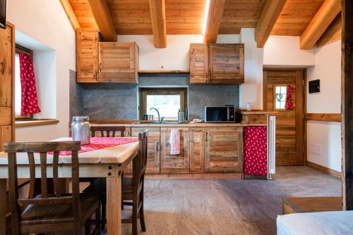 瓦托内切la casa dei nonni的厨房配有木制橱柜和桌椅