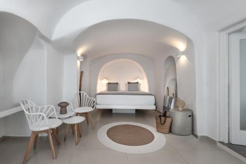 伊亚卡尔德拉尊贵别墅酒店的一间白色客房内的床铺卧室