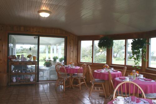新肖雷汉姆Rose Farm Inn的用餐室配有粉红色的桌椅