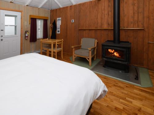 佩尔塞奥匹劳洛尔小屋汽车旅馆的一间卧室配有一张床和一个燃木炉子