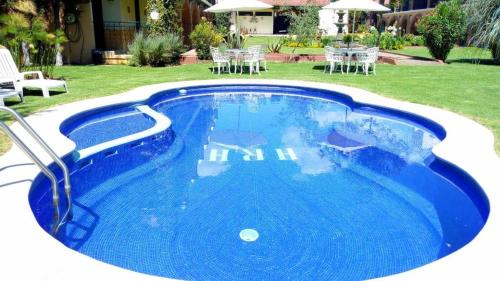 瓦斯卡坎波里尔华斯卡酒店的蓝色的游泳池配有椅子和桌子