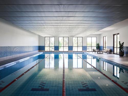 WallanHidden Valley Resort的一个带蓝色瓷砖和窗户的大型游泳池