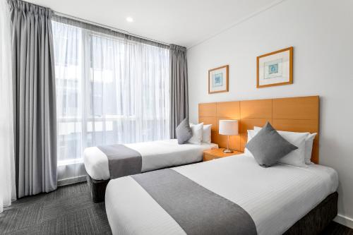 墨尔本探索南岸酒店的酒店客房设有两张床和窗户。