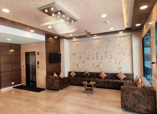 乌代浦Treebo Trend Opulence Inn - Near City Palace的大堂配有沙发、电视和桌子。