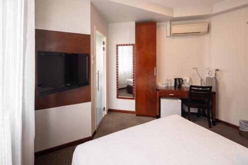 新加坡The Quay Hotel West Coast的配有一张床和一张书桌的酒店客房