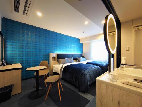 名古屋Green Rich Hotel Nagoya Nishiki (Artificial hot spring Futamata Yunohana)的一间卧室设有一张床和蓝色的墙壁